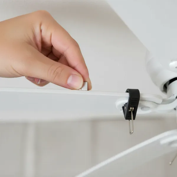 Close-up of a hand attaching a balancing weight to a ceiling fan blade with a balancing clip, demonstrating precision and DIY spirit.